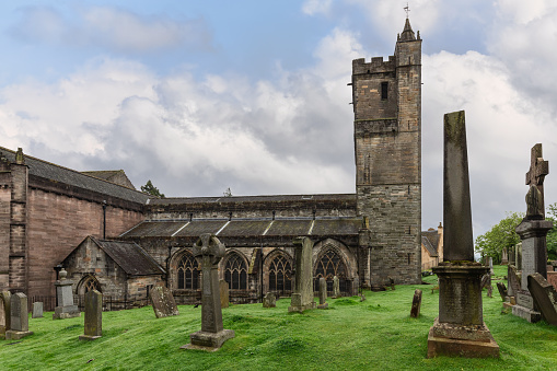 Amidst Stirling's verdant landscape, the Church of the Holy Rude's sturdy tower overlooks time-worn gravestones. Stirling, Scotland