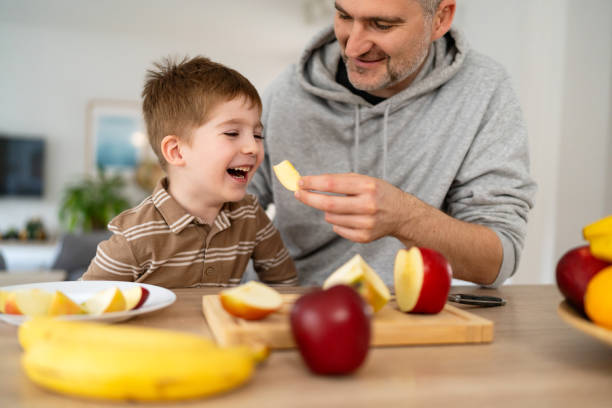 istock Dad and son eating fruit together at home 2077635214