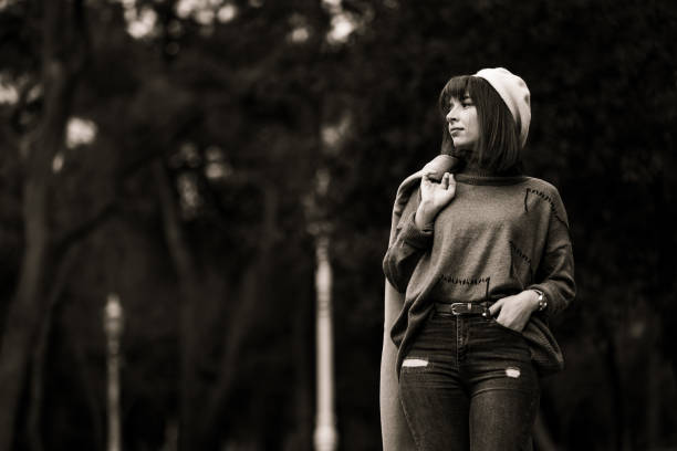 Pretty young lady is walking around at public park in autumn.