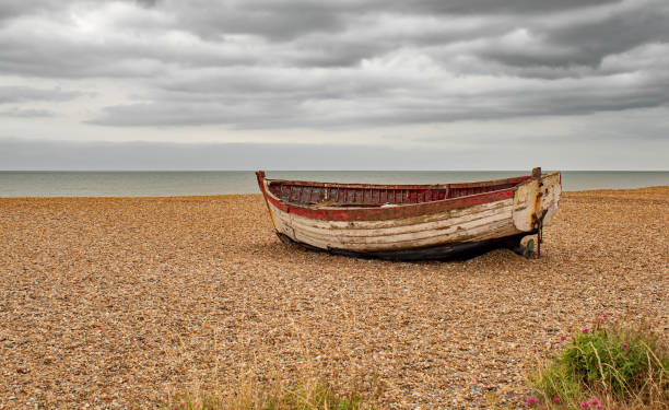istock The old boat on a shingle beach with a moody grey sky 2077667821