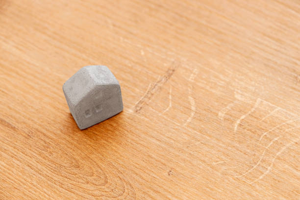 Miniature concrete toy house on wooden background. Copy paste for text.