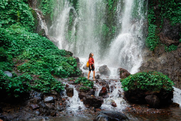 istock Woman exploring near the refreshing waterfall on Bali 2077692413