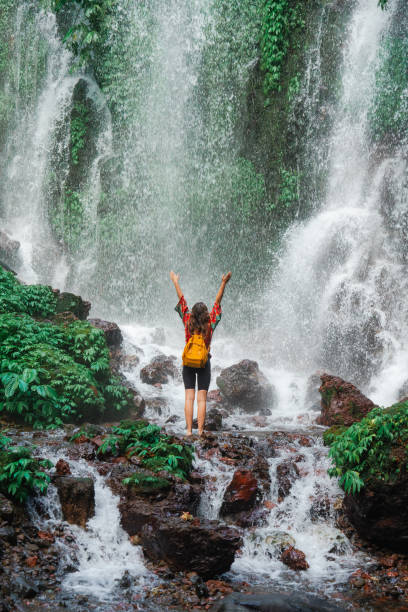 istock Woman standing near the refreshing waterfall on Bali 2077692935