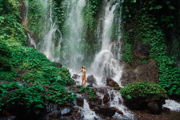 istock Woman swimming in the waterfall on Bali 2077693464