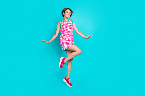 Full body length photo cadre of jumping trampoline graceful lady glamour style dress pink sneakers isolated on aquamarine color background.