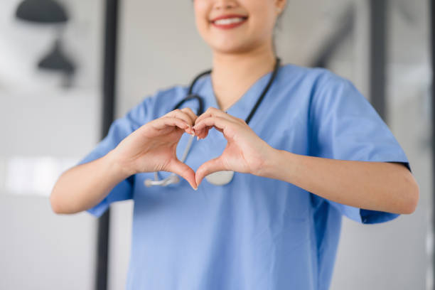 istock Caring Nurse Making Heart Gesture in Clinic. 2077722449