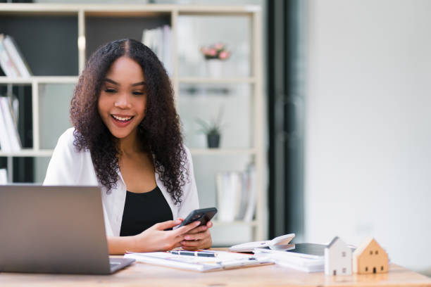 istock Happy Young Businesswoman Using Mobile Phone at Workstation. 2077725226