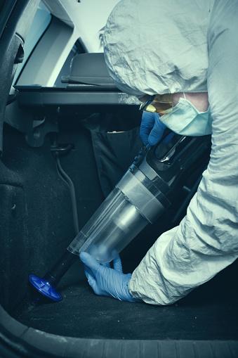 Criminologist technician collecting evidence with vacuum and micro filter