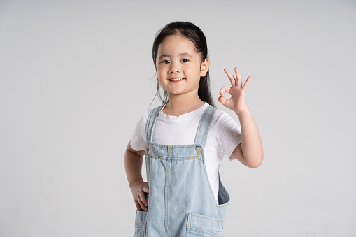 8 years old girl standing against white background.