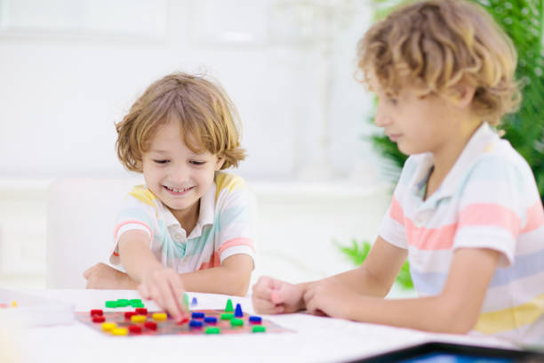 Family playing board game at home. Kids play strategic game. Little boy throwing dice. Fun indoor activity for summer vacation. Siblings bond. Educational toys. Friends enjoy game night.