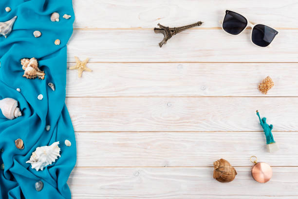 istock Seashells, sunglasses, compass souvenirs blue fabric and starfish on white planks vacation planning background flat lay with copy-space 2077789723