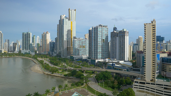 Sun shining on modern financial district with tall skyscrapers in Panama City. Picturesque seaside with high-rise buildings reaching into sky. Business and tourist destination in Central America.