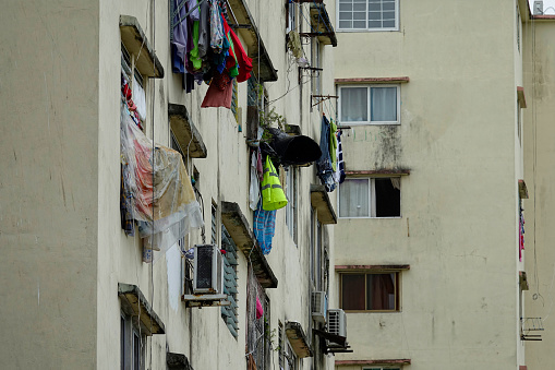 Drying laundry on window with rain protection in high-rise residential buildings. Resourcefulness in deprived neighbourhoods. Glimpse of authenticity during exploration of urban areas while traveling.
