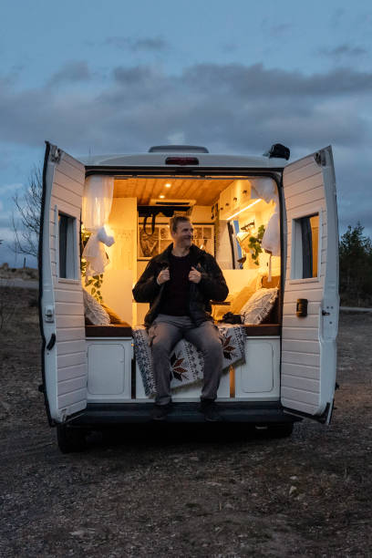 istock Mature man sitting in the back of a camper van during sunset 2077808973