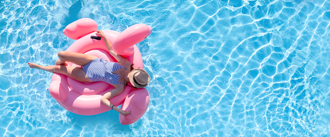 Woman in Bikini on Inflatable Flamingo in Pool, Aerial View with Copy Space