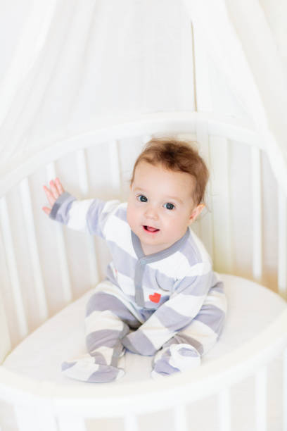istock Baby in a white crib. Child in bed. 2077818478
