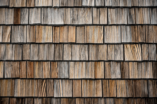 Wood shingles thin, tapered pieces of wood on the wall of a building in the Austrian Alps.