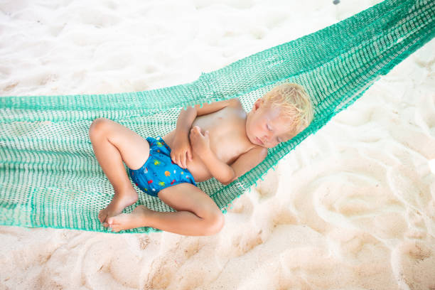 istock Baby sleeping on tropical beach. Child in hammock. 2077826953