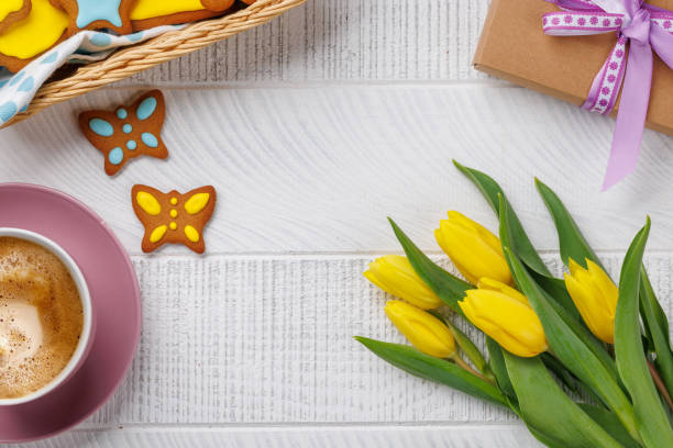 Easter Scene with Gingerbread Cookies, Yellow Tulips, and Coffee Cup. Flat lay with copy space