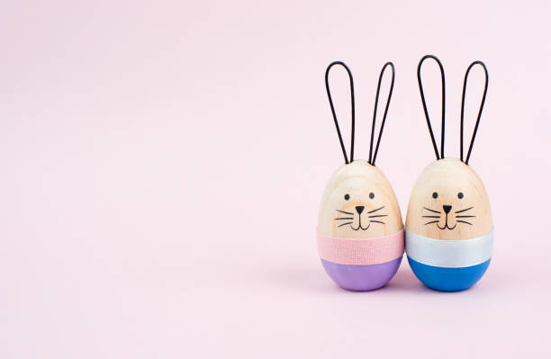 istock Easter bunny or rabbit couple cuddle together, wooden egg, spring holiday greeting card 2077852446
