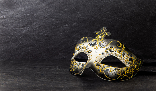 White and black Venice mask isolated on brown paper background.