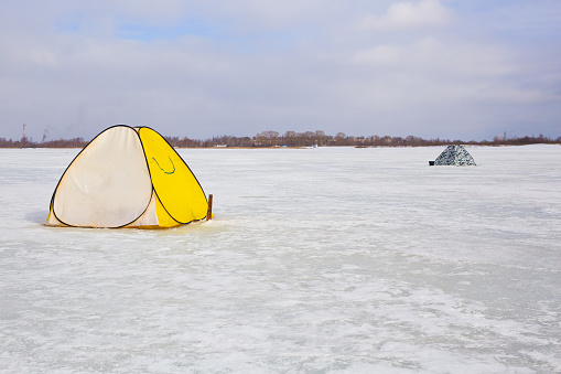 fishing tents stand on the ice of the lake.