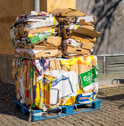 Stockholm, Sweden - Large bundles of branded cardboard boxes, crushed and compacted for recycling collection.