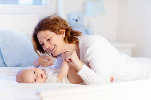 istock Mother and baby on a white bed 2077897979