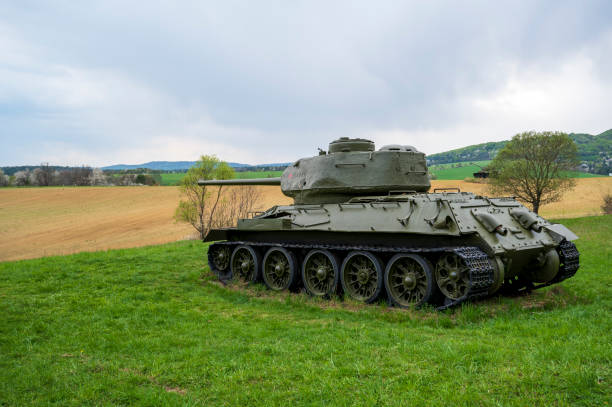 istock Old Soviet tank is parked on green meadow. 2077930079