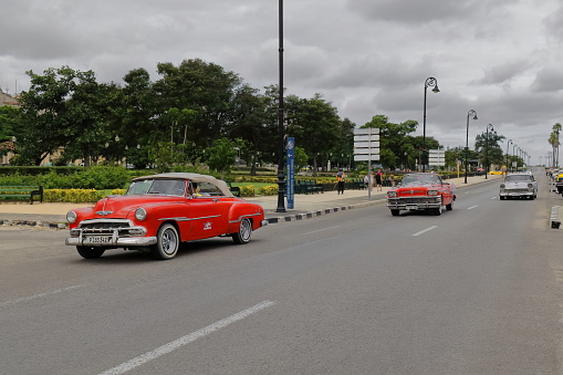 Havana, Cuba-October 7, 2019: American classic cars Chevrolet Styleline Deluxe Convertible '52, Buick Century Convertible '58, Chevrolet Bel Air Sedan '56 drive along Avenida del Puerto-Port Avenue.