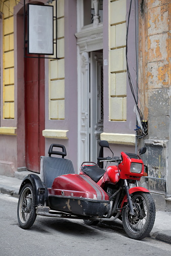 Havana, Cuba-October 7, 2019: Old, classic, red painted, Czech-made motorcycle from 1991 -Jawa 350 cc, Type 640- with attached sidecar -Velorex Type 560- stations by the curbside on Virtudes street.