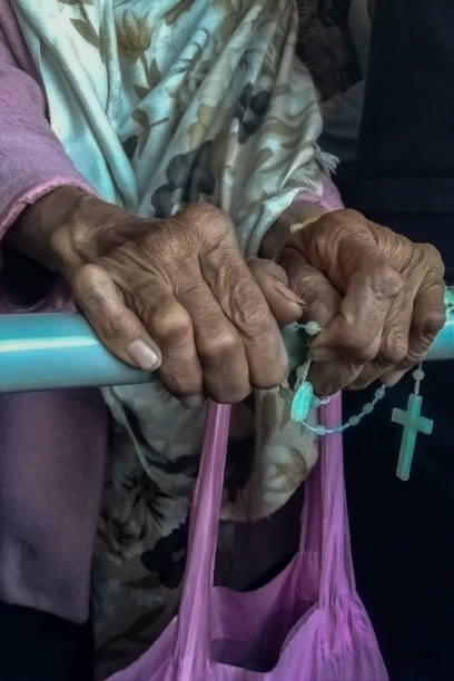 mãos de mulher idosa com um crucifixo - nun sign holding women - fotografias e filmes do acervo