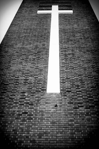 Low Angle photo of a church tower facade with religious cross.