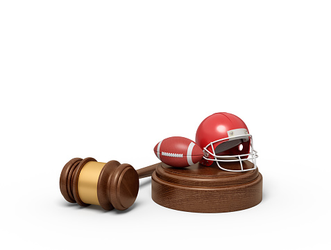 3d rendering of ball and helmet for American football on sounding block with judge gavel lying beside. Sport law cases. End up in court. American football seeks justice.