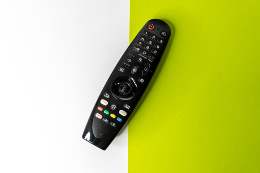 TV remote control on pastel background. Top view, minimalism