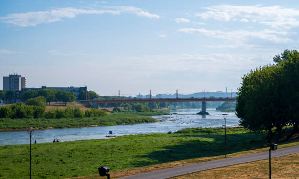 istock Calm river flows through the forest, meadows and the city 2078030054