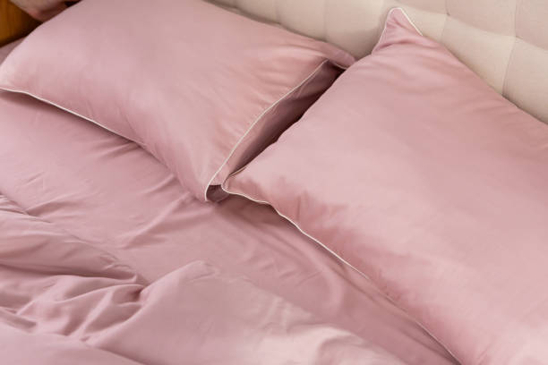 istock pale pink satin bed linen and pillows 2078055355