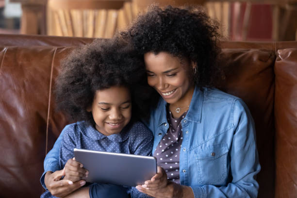 istock African mother her little daughter having fun using digital tablet 2078056433
