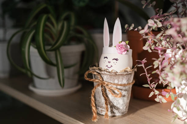 istock Children's Easter craft as decor on a shelf among house plants. DIY Easter Bunny Craft 2078108051