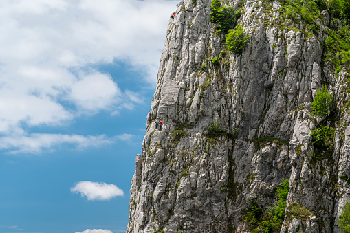 Some people are climbing a rock of the Grigna mountains near Rosalba refuge, Piani dei Resinelli, Lombardy, Italy