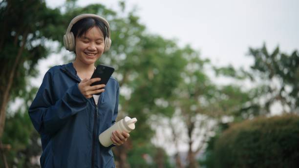 istock Asian girl using phone at park. 2078140772
