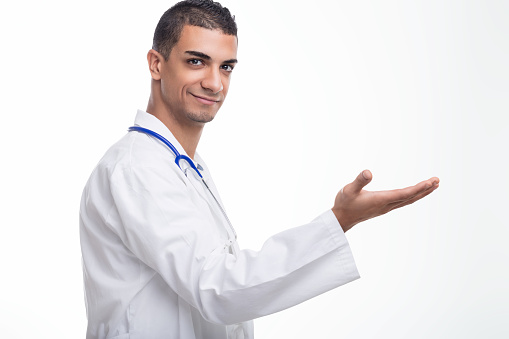 Smiling medical professional extends an open hand, suggesting care and readiness to assist