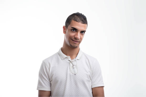 Person in white polka dot shirt displays a quiet assurance, with a faint smile and sharp gaze