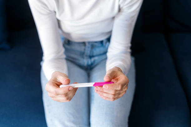 mujer comprobando el resultado de la prueba de embarazo confirmada - clínica de abortos fotografías e imágenes de stock