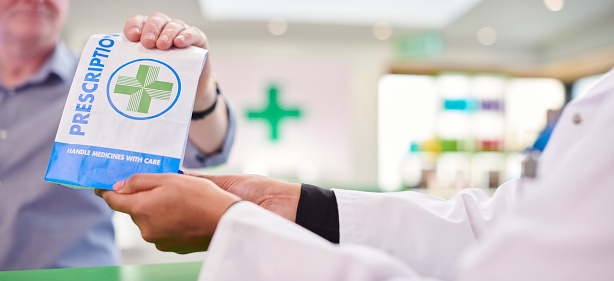 female pharmacist handing prescription
