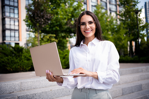 Photo of elegant lovely lady professional real estate agent hold macbook bookin apartment house hotel online spring season