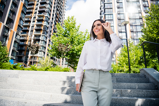 Photo of gorgeous lovely lady dressed stylish white shirt eyeglasses going office carrying wireless netbook spring daylight outdoors.