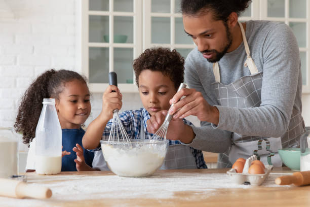 istock Loving African dad teach kids cooking in kitchen 2078185458