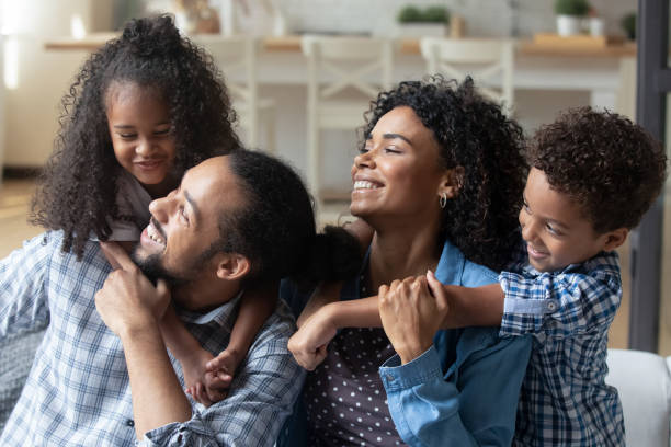 istock African couple and kids hugging sit on sofa at home 2078197034