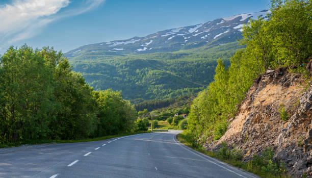 istock Winding asphalt road in green forest under high hill 2078201280